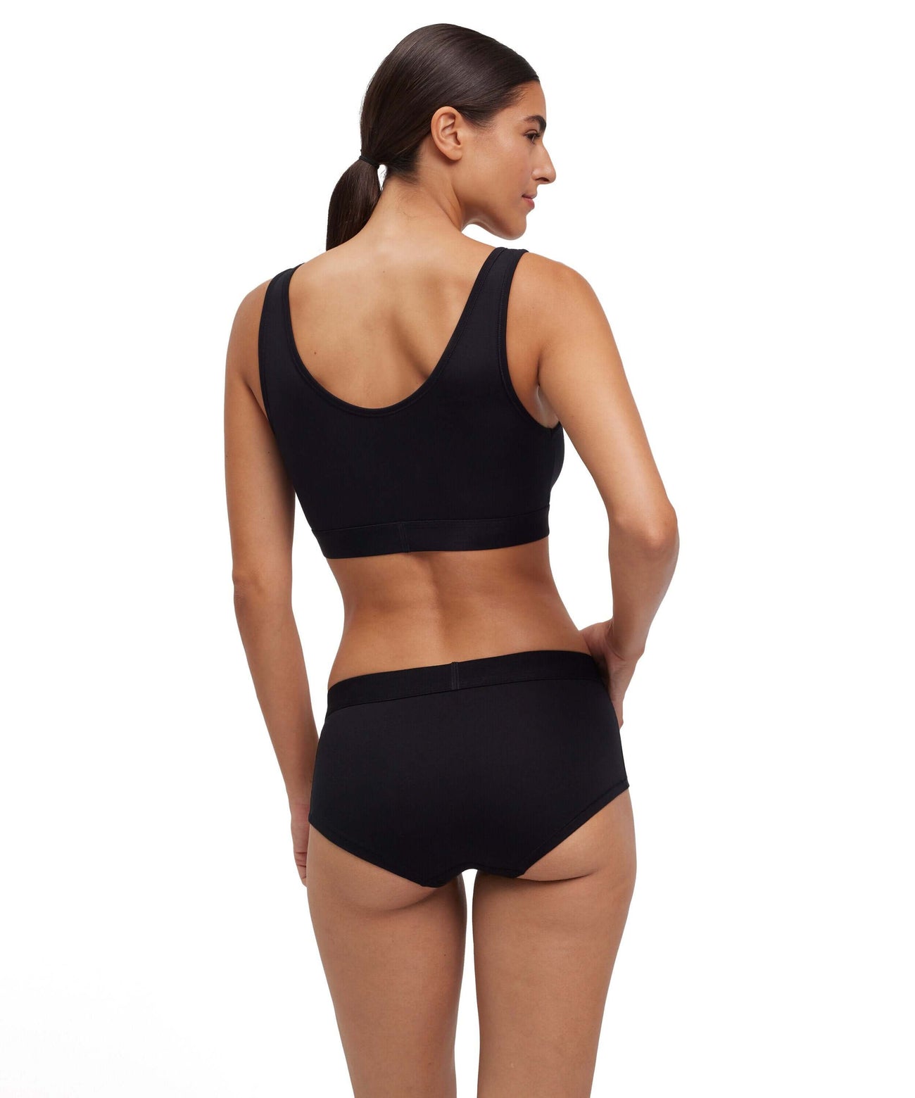 Vrouw in zwarte FALKE bustier en ondergoed, zichtbaar achteraan, voor dagelijks comfort.
