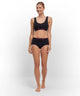 Model in FALKE hipster en sportbh, zwart met roze logo, voor ultiem comfort en perfecte pasvorm.