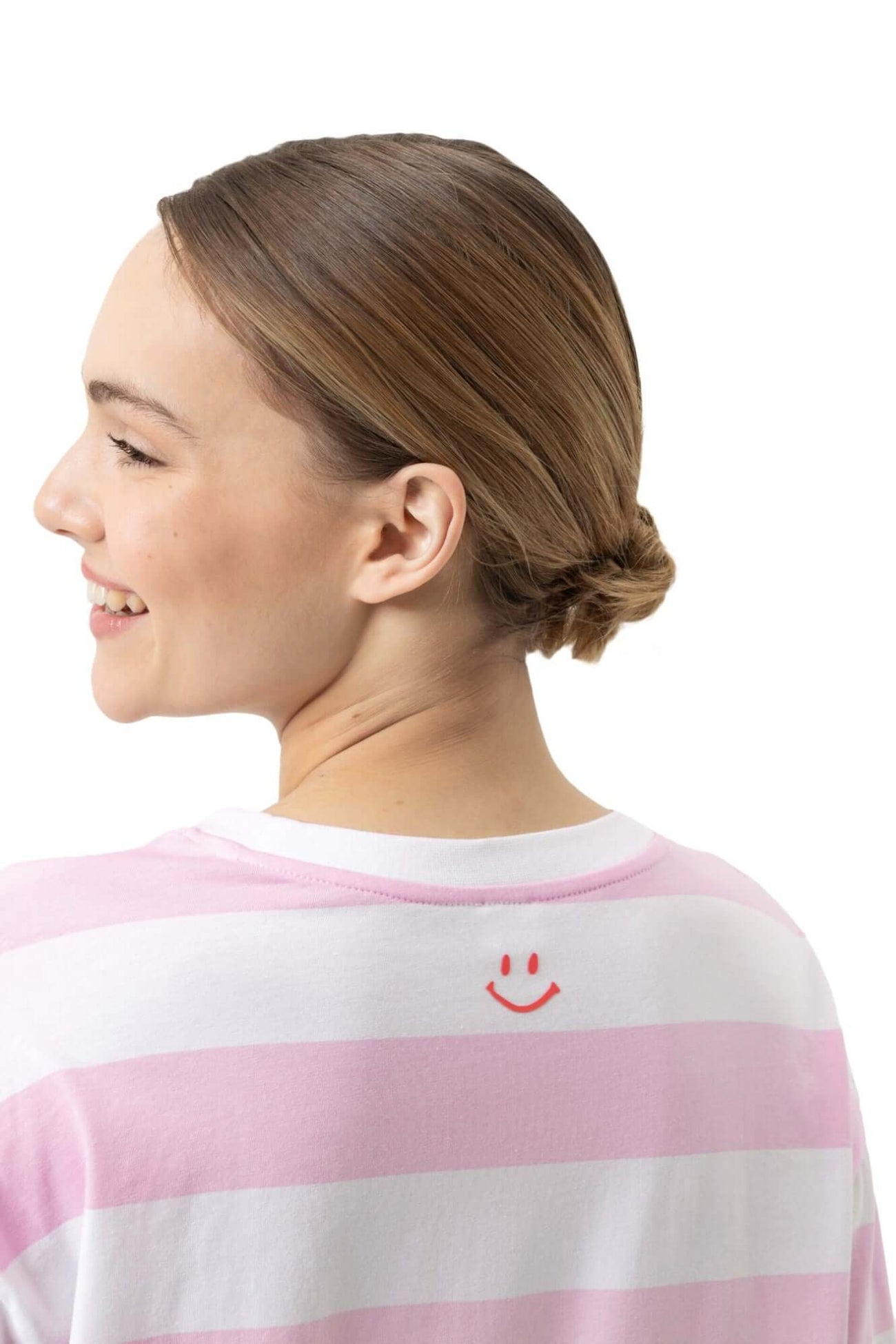 Achterzijde van een vrouw in een roze-wit gestreept nachthemd met een glimlach opdruk op de rug.