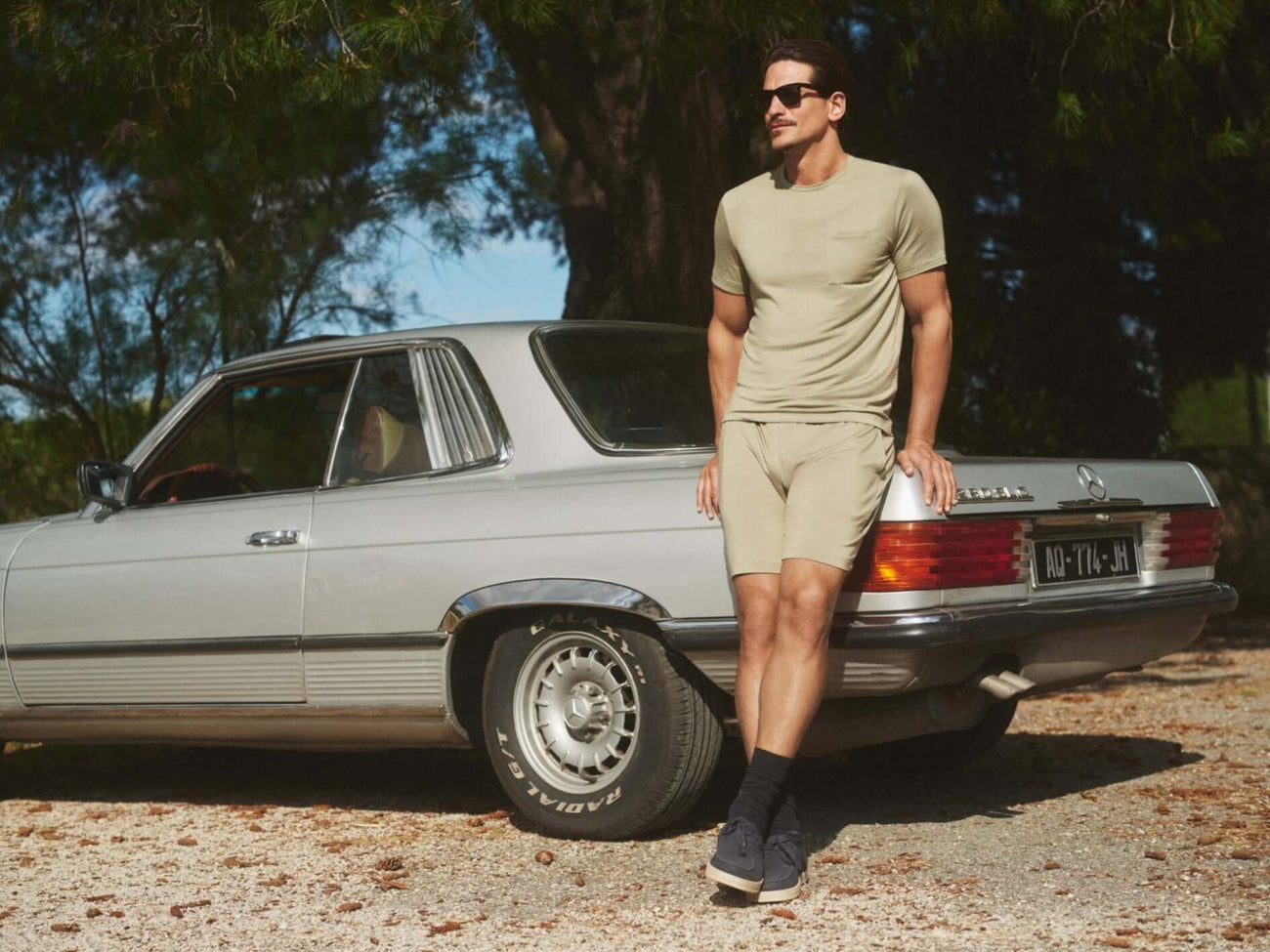 Mey T Shirt Jefferson Korte Mouw Heren 2210033 1781 faded olive aan een man, leunend op een auto, buiten bij natuurlijke omgeving.