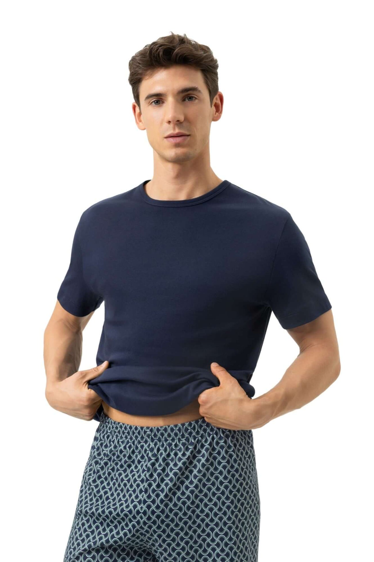 Mey Tweedelige Korte Pyjama Curves Heren 2240087 668 yacht blue, model in donkerblauwe shirt met golvende pyjamabroek.