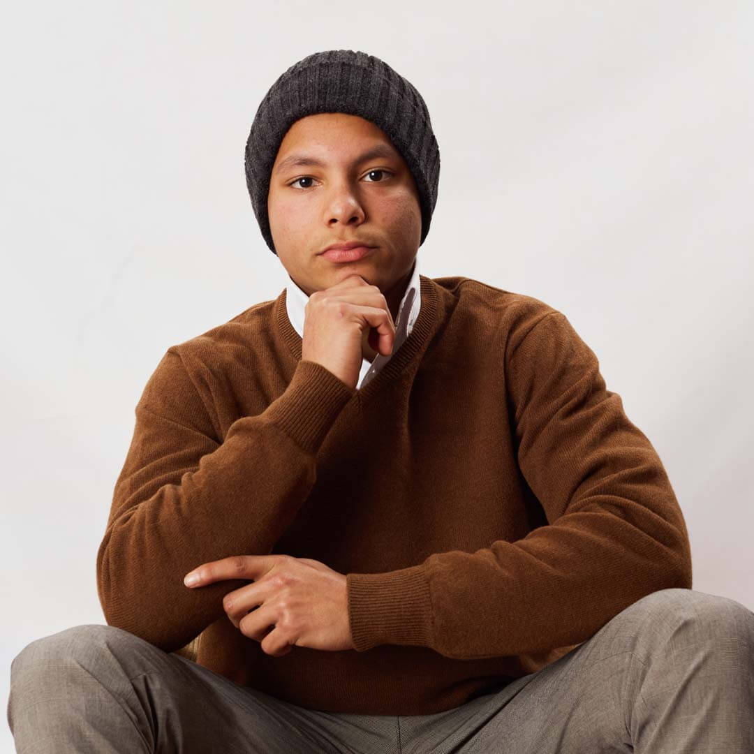 Osborne Heren Trui V-Hals Lamswol OMVS SPANI gedragen door een man met een muts, in een stijlvolle pose.