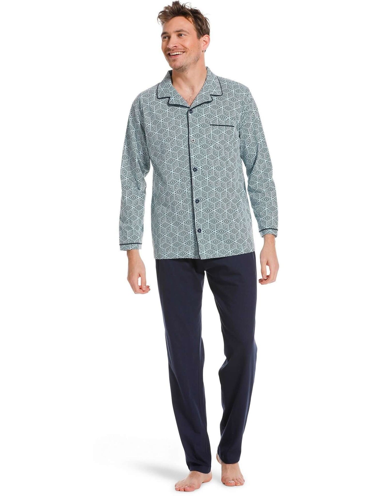 Man in een groene heren doorknoop pyjama van Pastunette met grafisch print en donkerblauwe details.