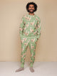 Snurk Alpaca Meadow Broek Unisex in een groene kleur met leuke alpacaprint, gedragen door een lachende man.