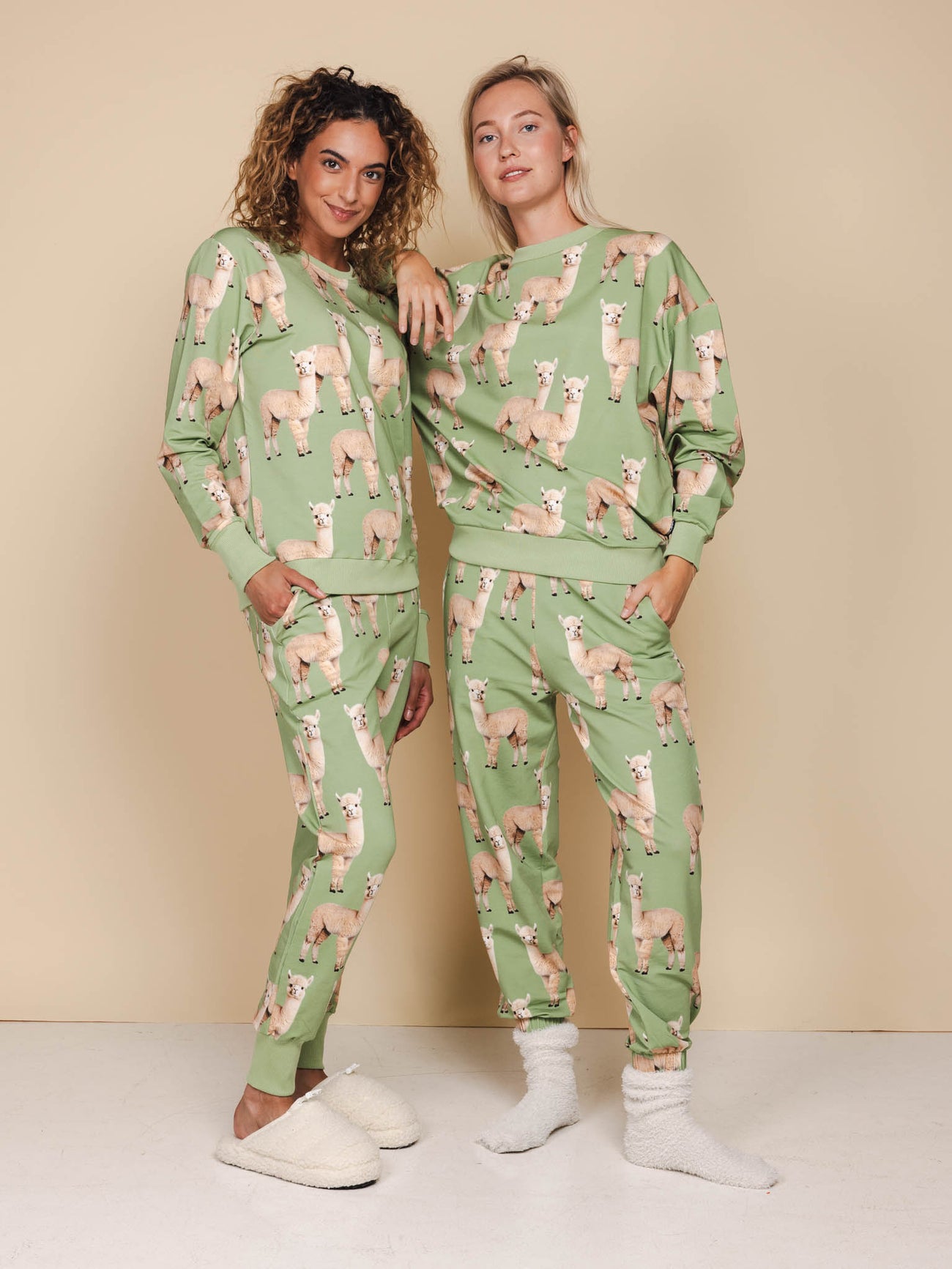 Modelen dragen de SNURK Alpaca Meadow Broek Unisex met grappige Alpacaprint, gemaakt van zachte biologische katoen.