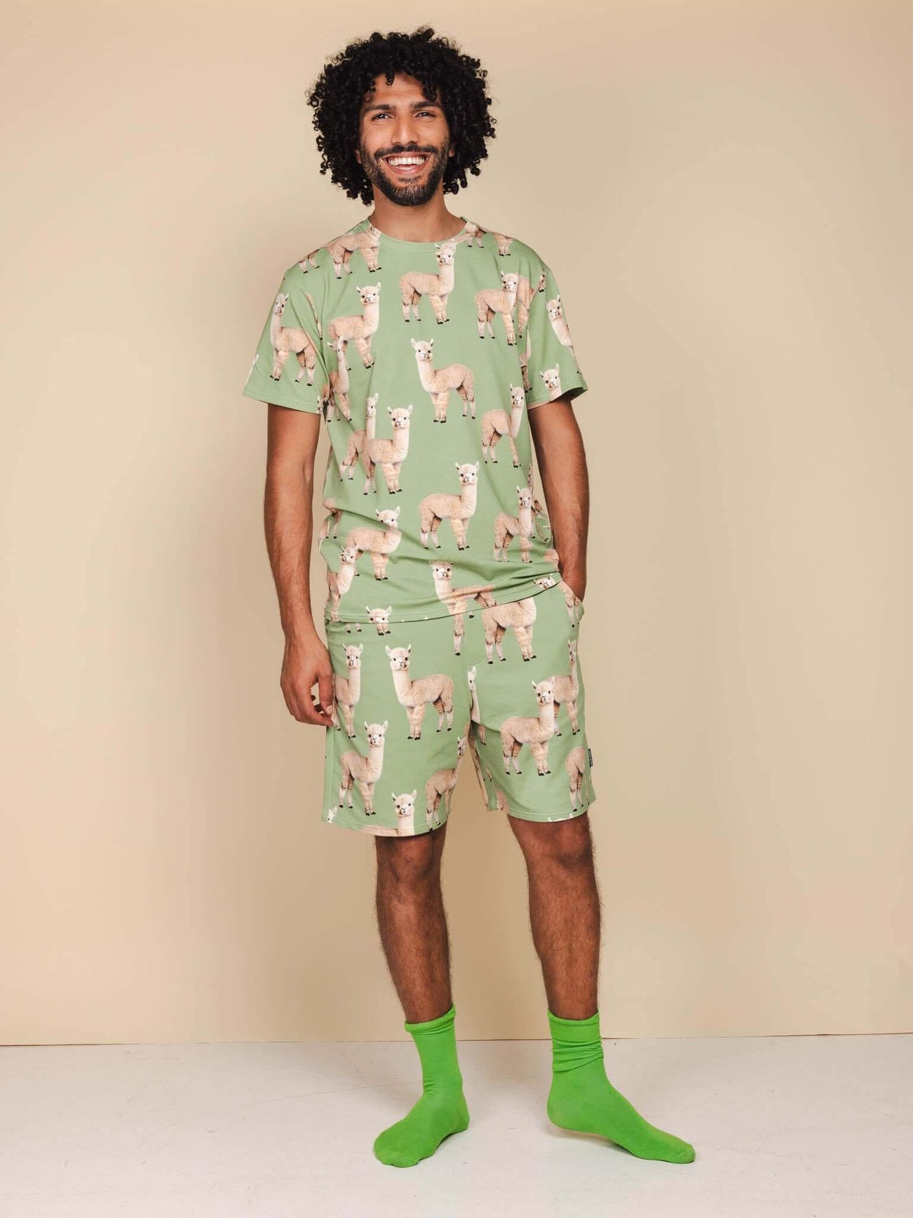 SNURK Alpaca Meadow Shorts Heren - Model in alpacaprint outfit met groene sokken.