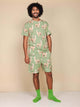 SNURK Alpaca Meadow Shorts Heren - Model in alpacaprint outfit met groene sokken.
