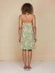 Vrouw met de SNURK Alpaca Meadow Strap Dress Dames, een groen jurkje met alpacaprint, gezien van achteren.