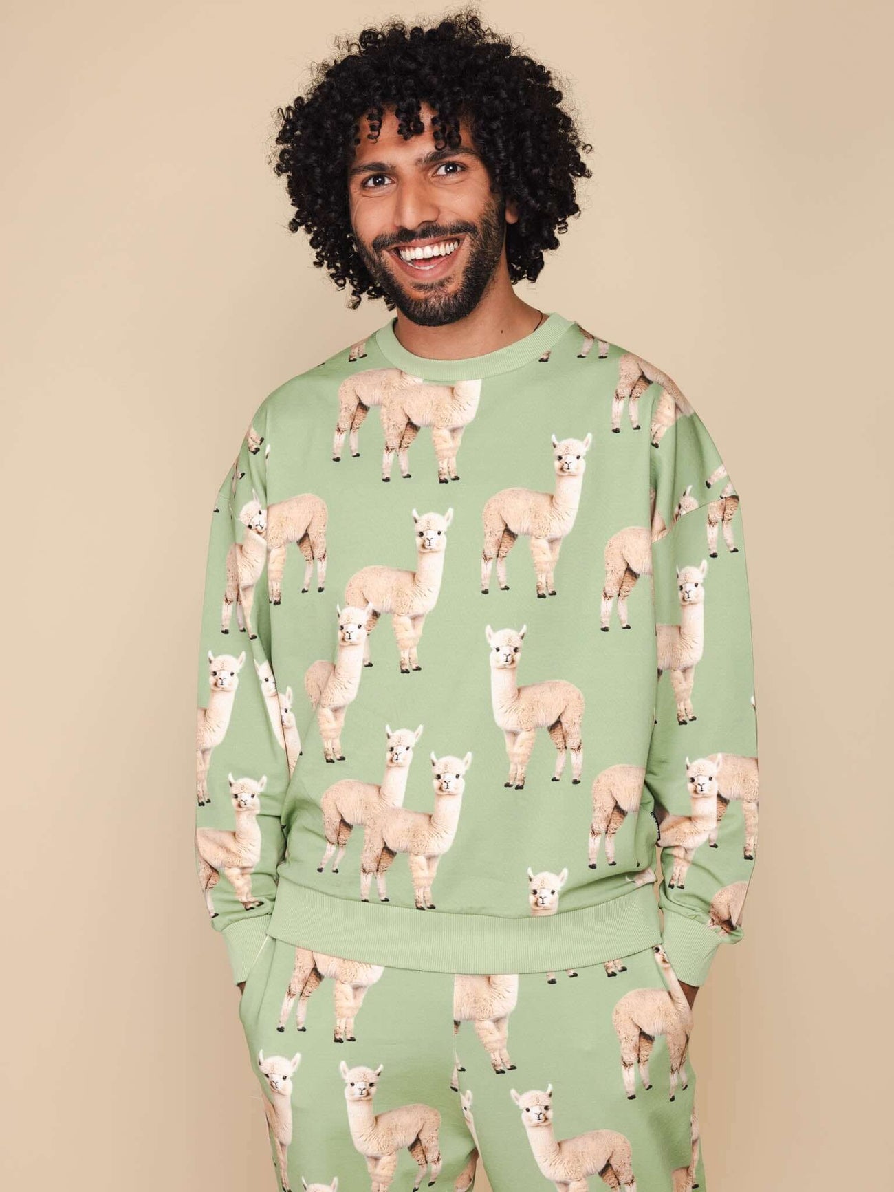 SNURK Alpaca Meadow Sweater Heren met grappige Alpacaprint op een man met krullend haar.