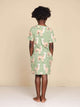 Achteraanzicht van een kind in de SNURK Alpaca Meadow T-shirt Dress Kids met vrolijke alpacaprint.