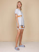 Vrouw in SNURK Baguette T-shirt Unisex met stokbroodje, casual look, bio-katoen, lichte kleur.