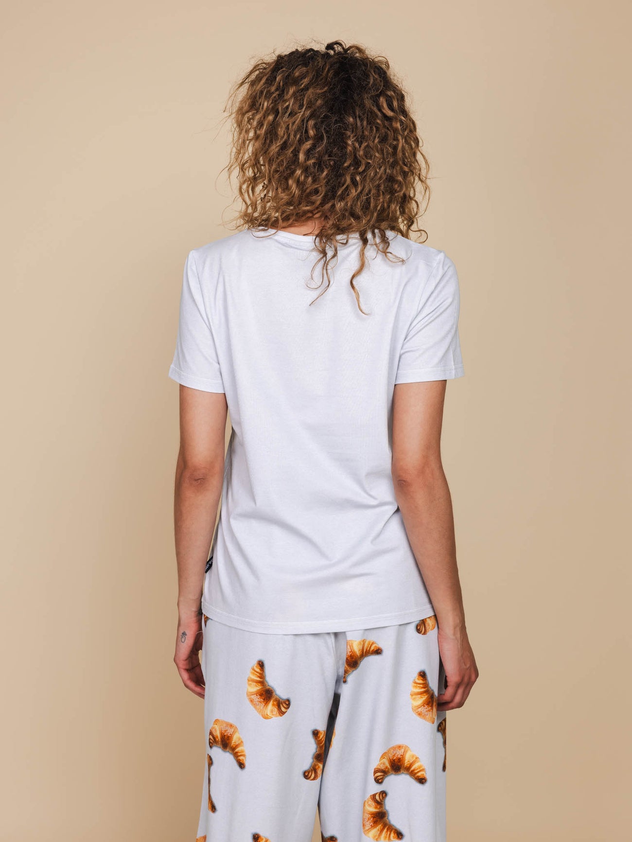 Achterkant van de SNURK Baguette V-Neck T-shirt Dames, gedragen met comfortabele kleding.