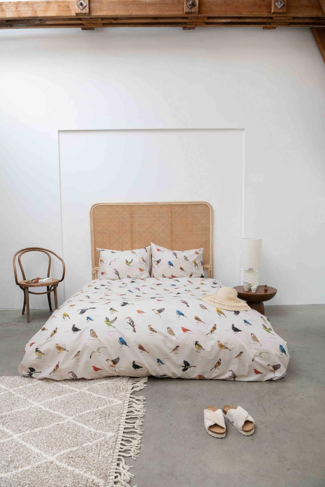 SNURK Bird Watching dekbedovertrek op bed met kleurrijke vogels en zachte bedaccessoires.