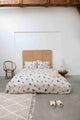 SNURK Bird Watching dekbedovertrek op bed met kleurrijke vogels en zachte bedaccessoires.