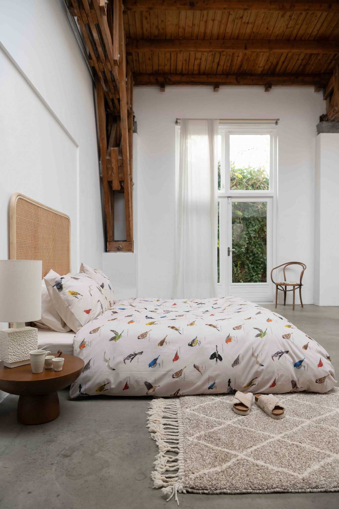 SNURK Bird Watching dekbedovertrek op een bed in een moderne slaapkamer met houten details.