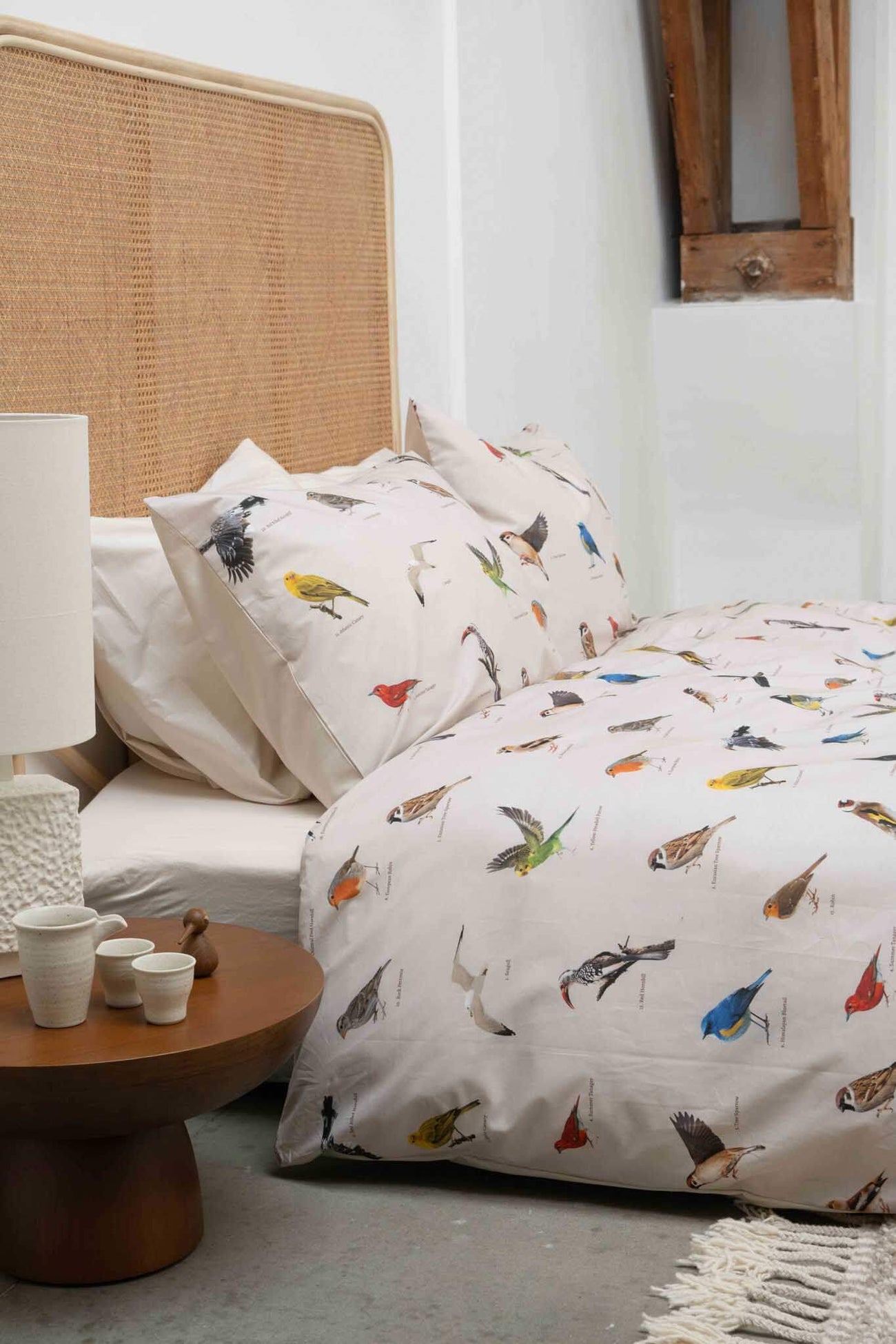 SNURK Bird Watching dekbedovertrek met kleurrijke vogels op beddengoed in een sfeervolle slaapkamer.