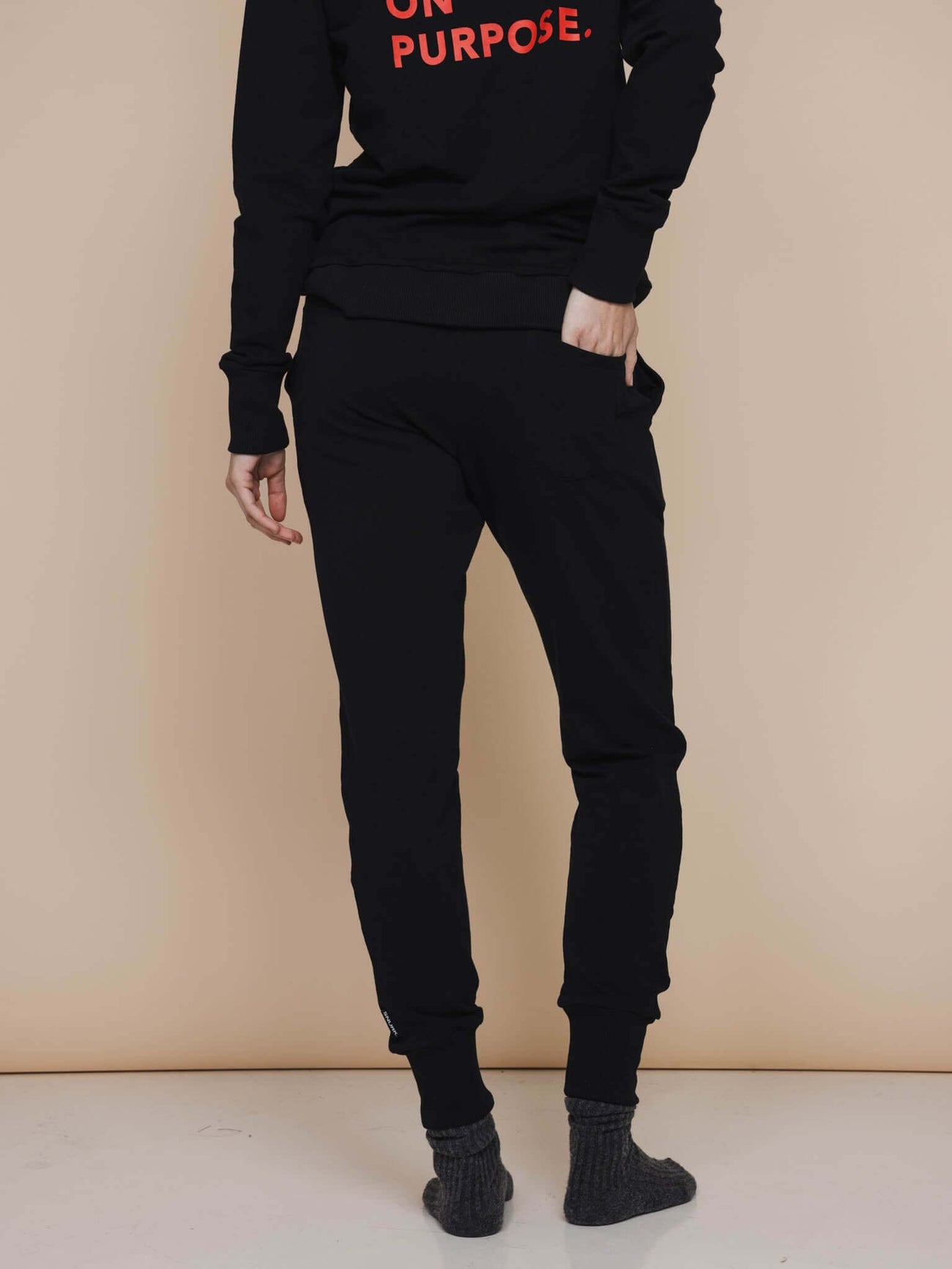 Model wearing SNURK Black Broek Regular Unisex, een comfortabele zwarte joggingbroek voor dames en heren.