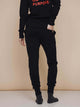 Model wearing SNURK Black Broek Regular Unisex, een comfortabele zwarte joggingbroek voor dames en heren.