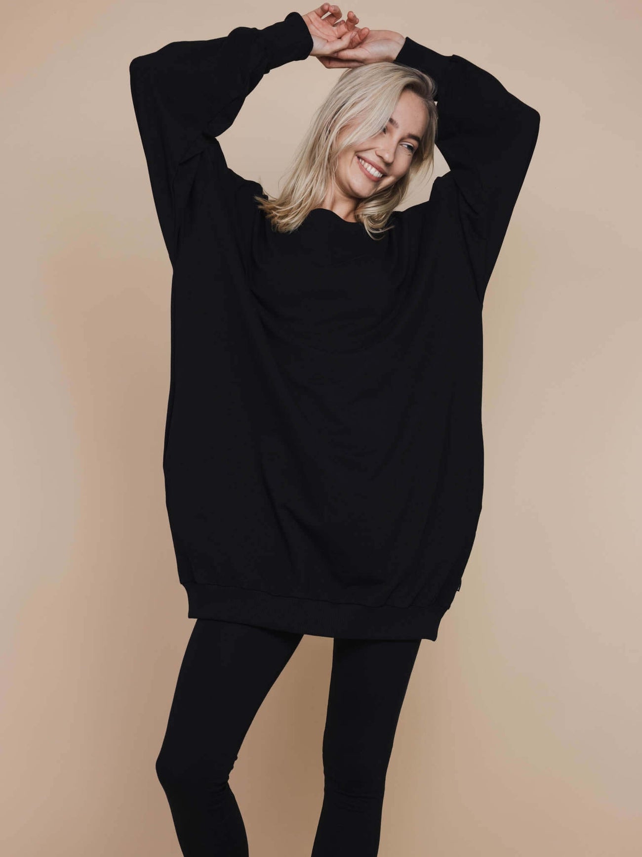 SNURK Black Legging Dames in combinatie met een losse zwarte jurk, model met een glimlach.