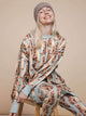 Een kindermodel in SNURK Bowie Legging Kids met kattenprint en comfortabele trui, glimlachend en stijlvol.