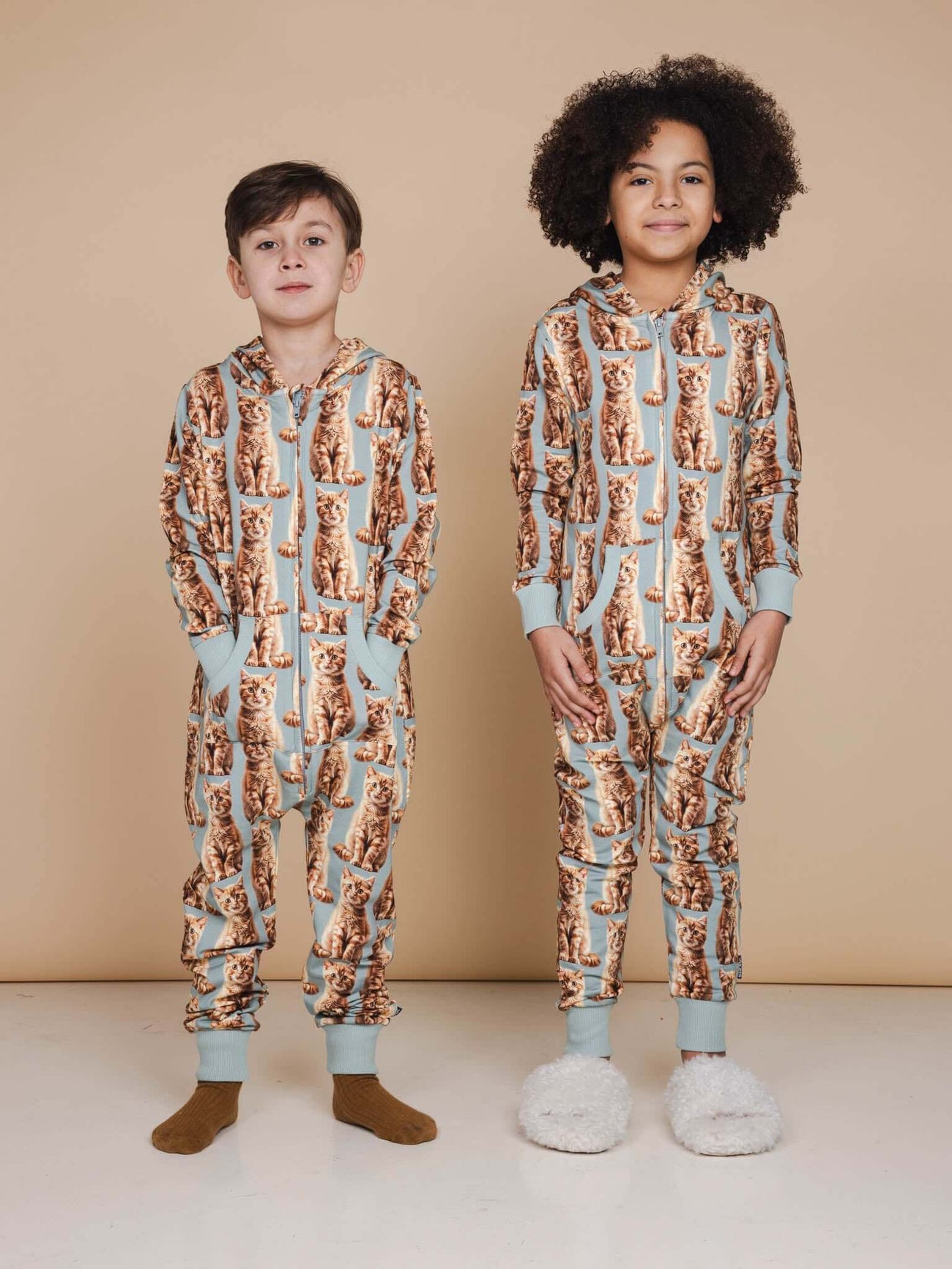 Kinderen in SNURK Bowie Onesie Kids met schattige kattenprint en comfortabele hoody.
