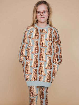 SNURK Bowie Sweater Dress Kids worn by a girl with cat print and matching leggings, perfect for comfort and chilling.