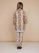 A girl wearing the SNURK Bowie Sweater Dress Kids with an all-over print of playful orange cats.