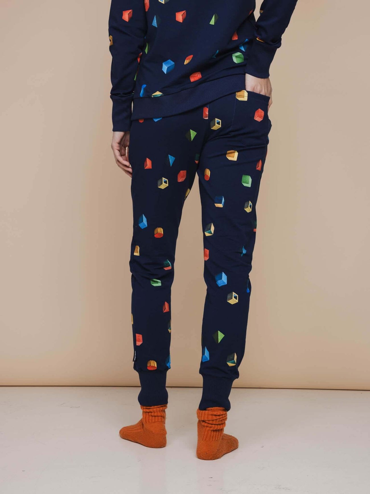 SNURK Building Blocks Broek Regular Unisex met kleurrijke houten blokken op een navy achtergrond.