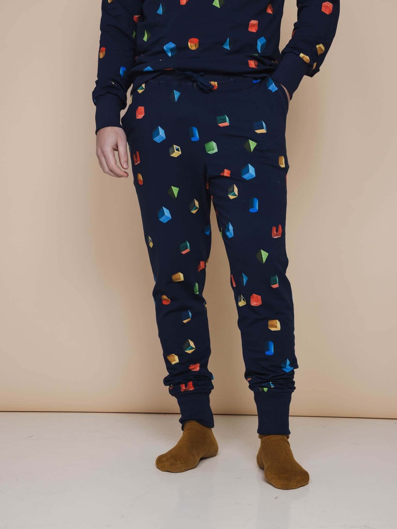 SNURK Building Blocks Broek Regular Unisex met kleurrijke blokken op navy achtergrond, perfect voor elke gelegenheid.