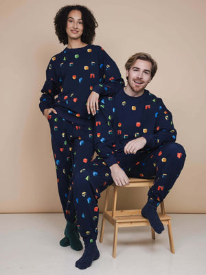 SNURK Building Blocks Broek Relaxed Unisex model vrijetijdskleding met kleurrijke blokken op een navy achtergrond.