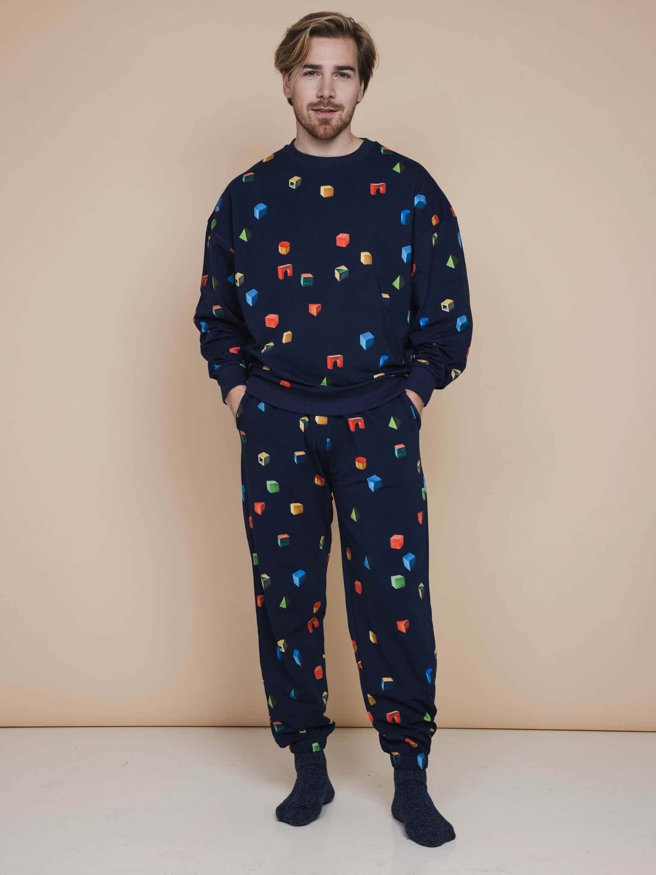 SNURK Building Blocks Broek Relaxed Unisex en sweater met kleurrijke houten blokken print op een navy achtergrond.