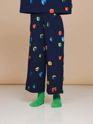 SNURK Building Blocks Wijde broek Kids met kleurrijke blokken op een donkerblauwe achtergrond.