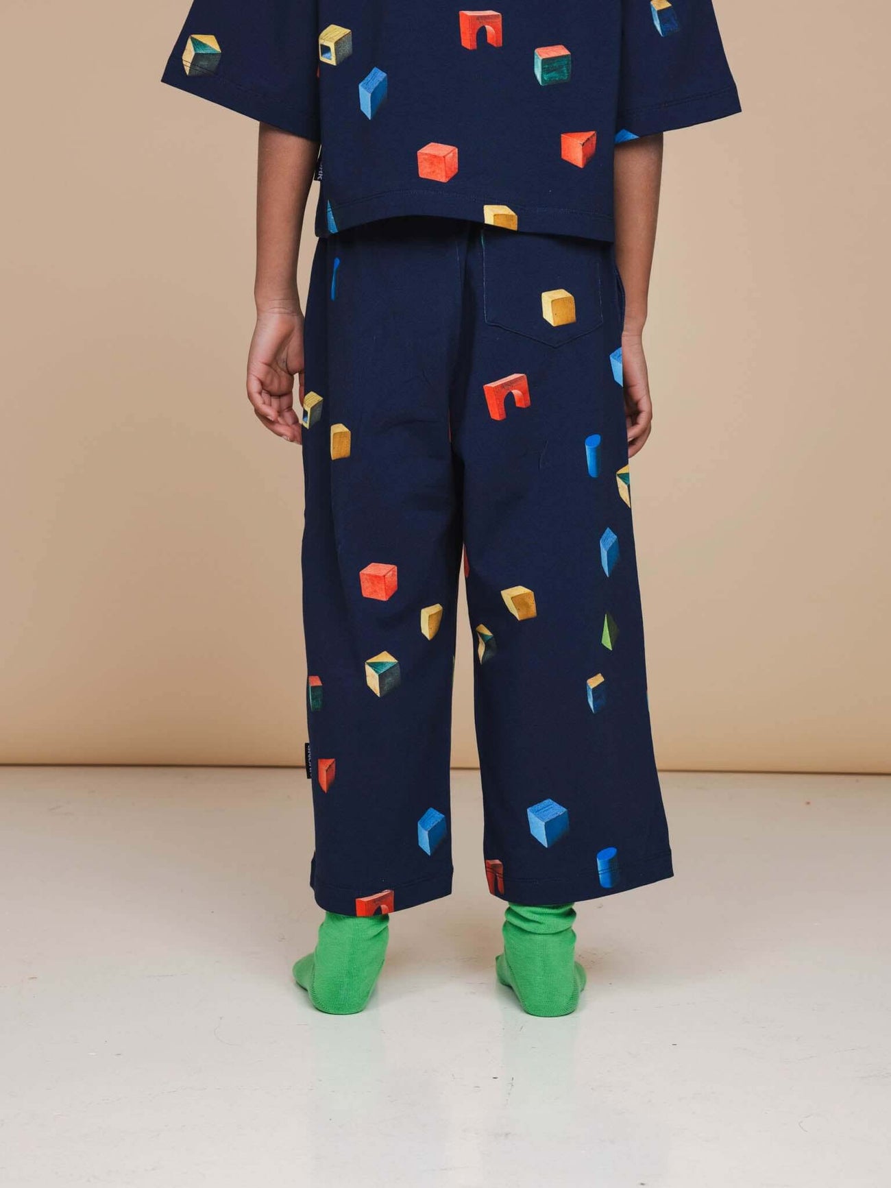 SNURK Building Blocks Wijde broek Kids met kleurrijke blokkenprint op een donkerblauwe achtergrond.