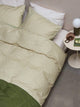 SNURK Check Green Beige dekbedovertrek met groen en beige geruit patroon op een bed.