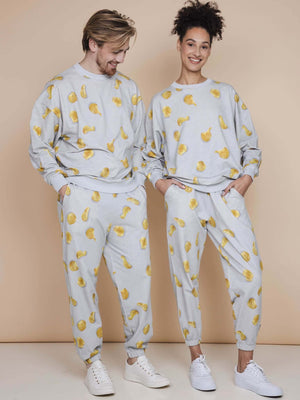 SNURK Chips Broek Relaxed Unisex in een relaxed fit met all-over print van chips op lichtgrijze achtergrond.