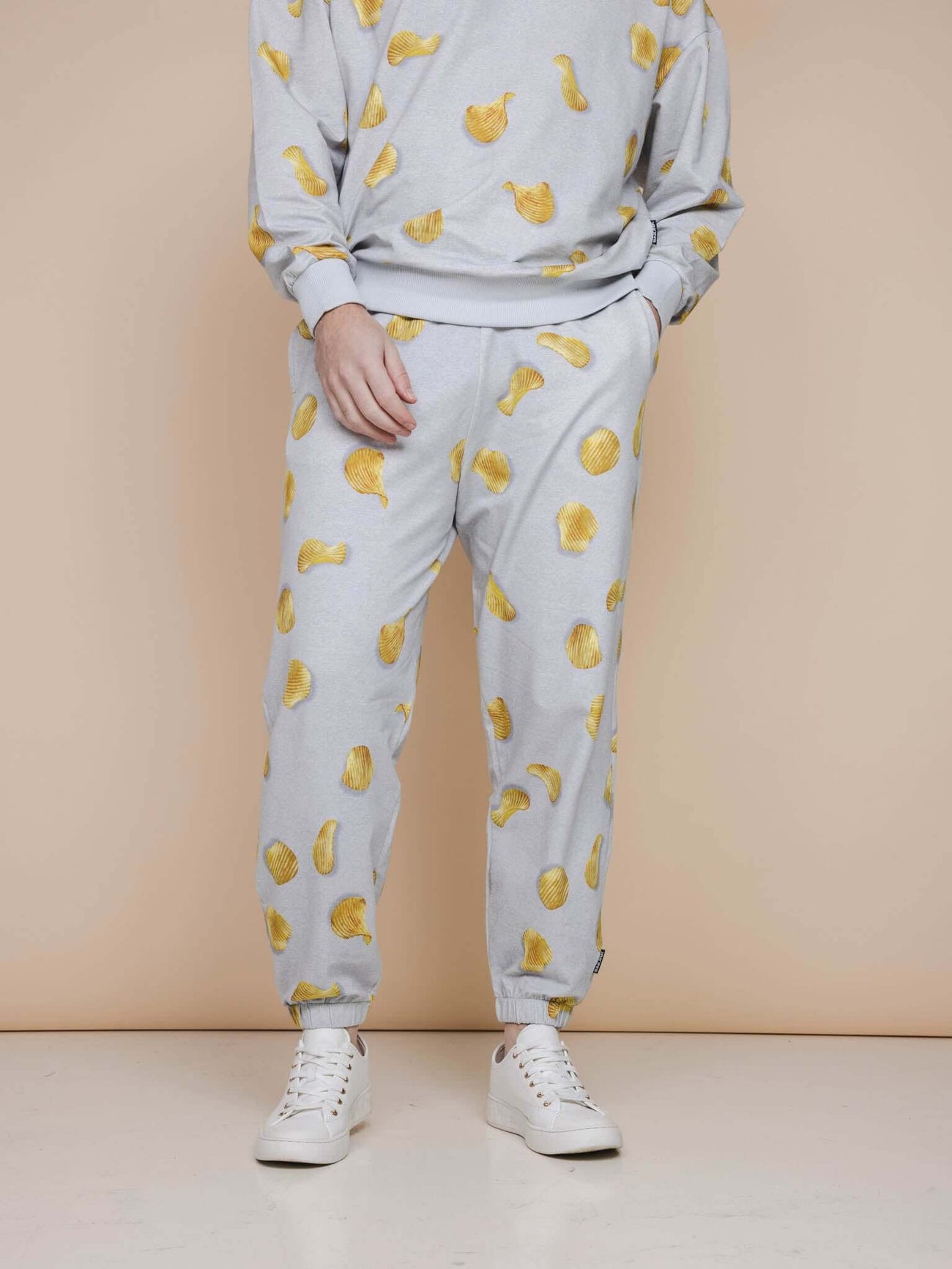 SNURK Chips Broek Relaxed Unisex met all-over print van naturel chips op lichtgrijze achtergrond.