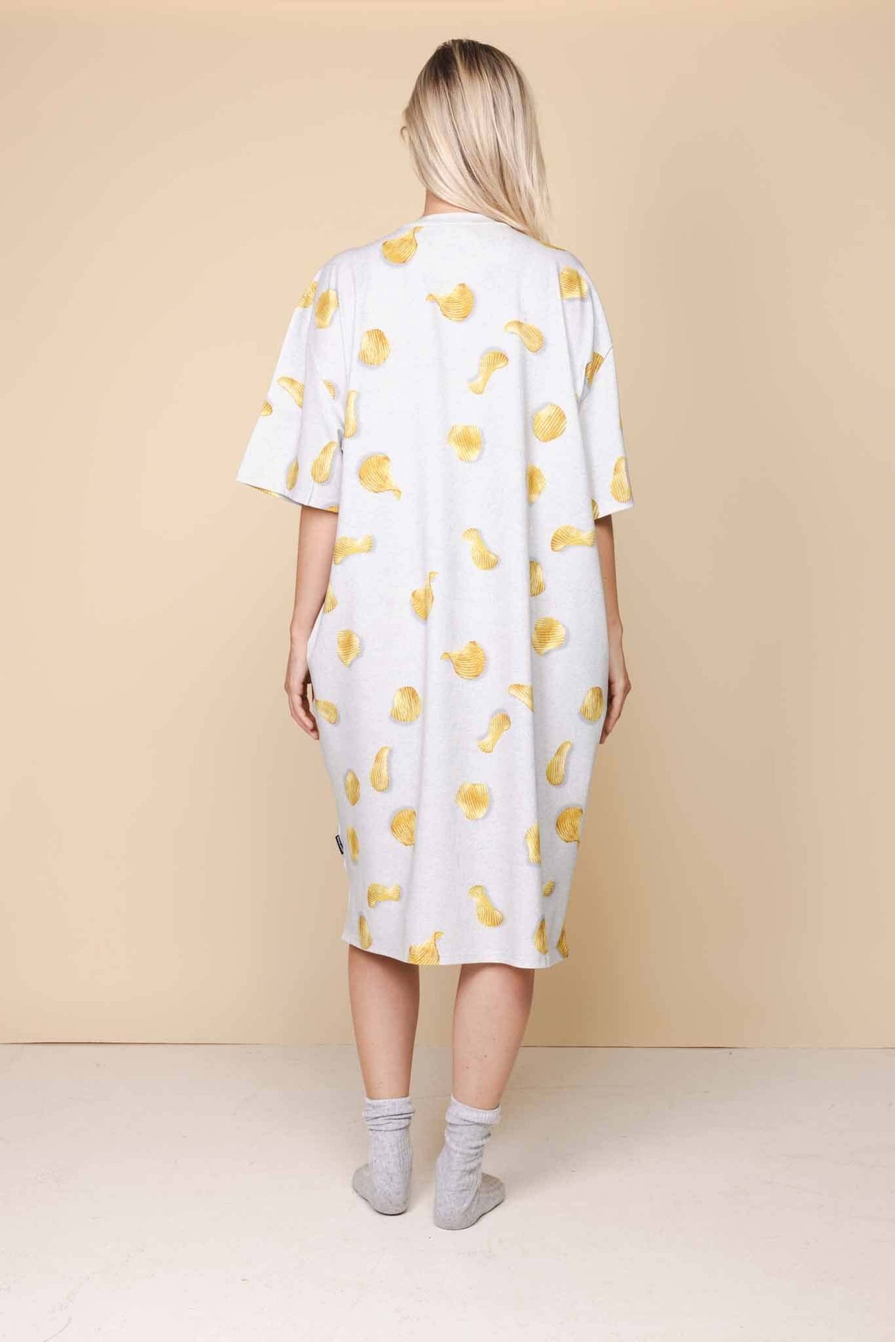 SNURK Chips Relaxed Tee Dress Dames in oversized fit met chipsprint aan de achterkant op een lichtgrijze achtergrond.