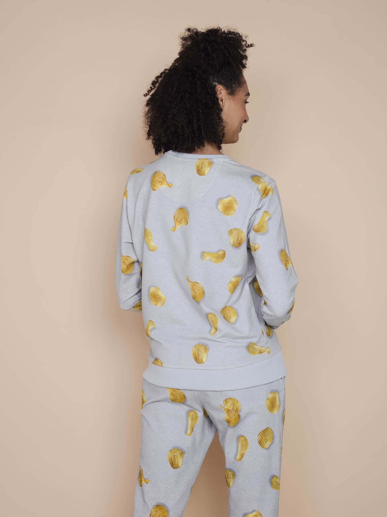 SNURK Chips Sweater Dames met all-over print van natuurlijke chips op een lichtgrijze basis.