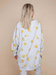 Model wearing the SNURK Chips Sweater Dress Dames with a playful all-over chips print on a light gray background.