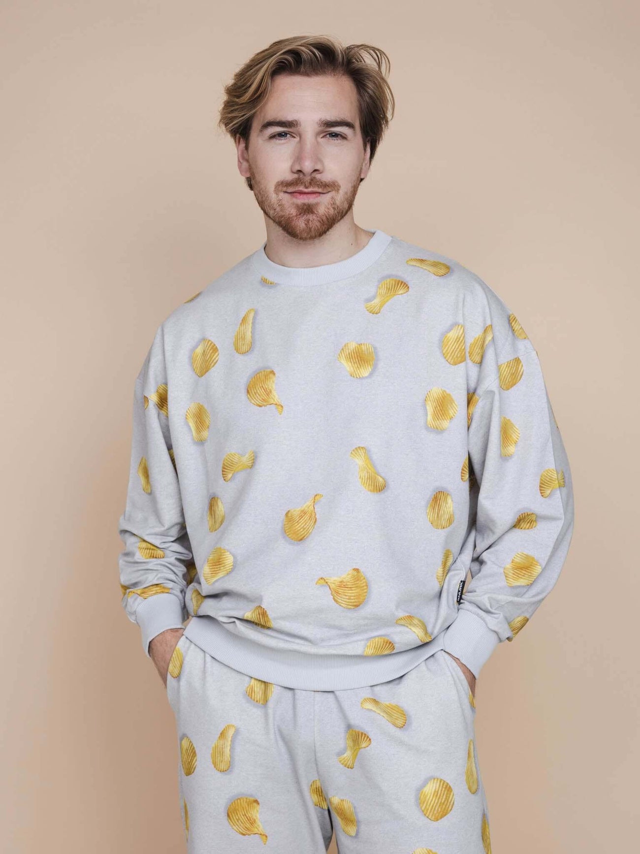 SNURK Chips Sweater Heren met all-over print van naturel chips op lichtgrijze basis.