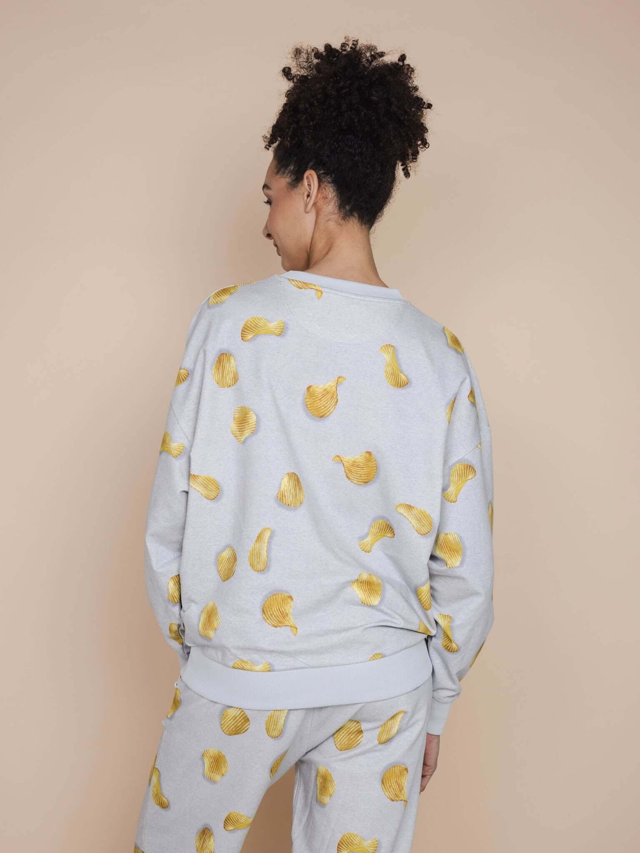 SNURK Chips Sweater Unisex met naturel chips op een lichtgrijze basis, ideaal voor relaxte outfits.
