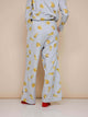 Achteraanzicht van de SNURK Chips Wijde broek Dames met een all-over chips print op een lichtgrijze basis.