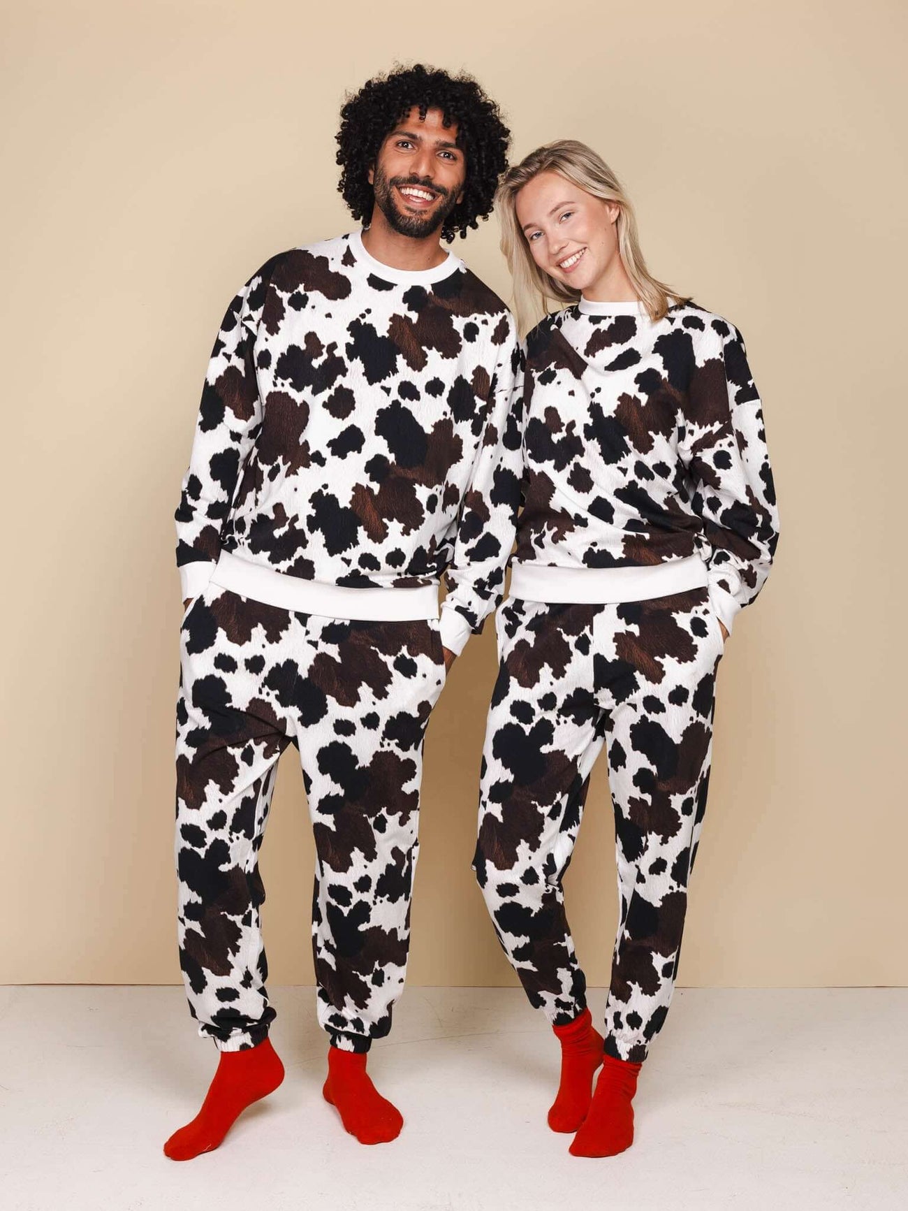 Modelen in SNURK Cow Sweater Heren met koeienhuidprint, perfect voor dag- en nachtgebruik.