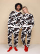 Modelen in SNURK Cow Sweater Heren met koeienhuidprint, perfect voor dag- en nachtgebruik.