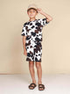 Jongen in een SNURK Cow T-shirt Kids met koeienprint, casual outfit voor kinderen met korte mouwen.
