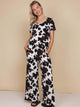 SNURK Cow Wijde Broek Dames model in koeienhuidprint met wijde pijpen en diepe steekzakken.