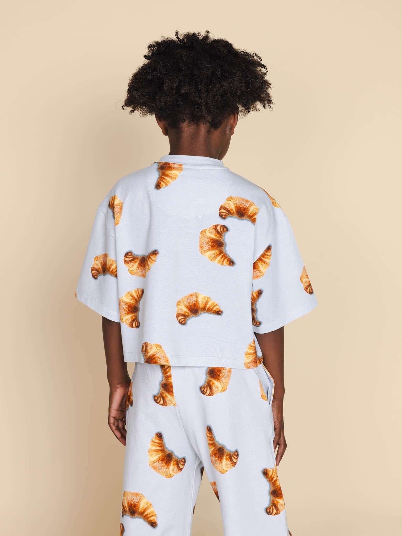 SNURK Croissants Cropped T-Shirt Kids met croissantprint op een kind