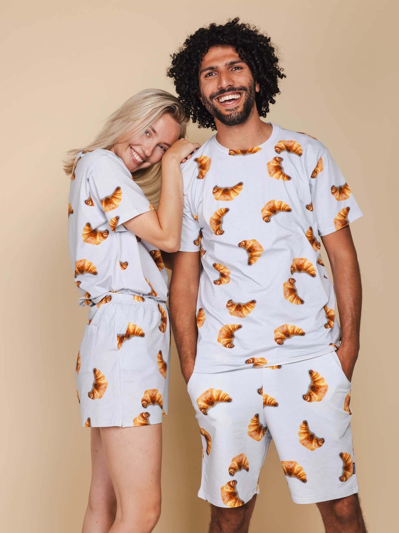 SNURK Croissants Shorts Heren model in matchende outfit met croissantprint, lachend en ontspannen pose.