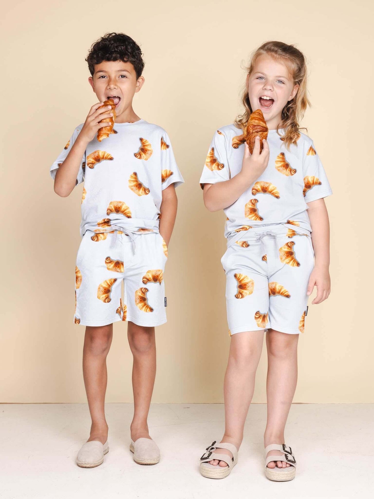 SNURK Croissants T-shirt Kids, kinderen in t-shirts met croissantjes en knapperige croissants in de hand.