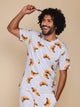SNURK Croissants T-shirt Unisex met een model in een croissant patroon op een beige achtergrond.